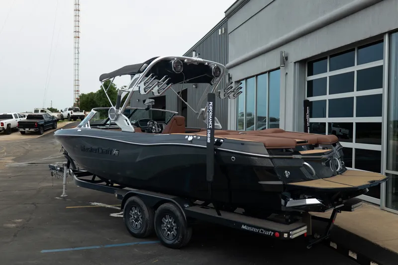 Slide: The Image of 2020 MasterCraft XT25 boat on trailer outside a modern building. - 6