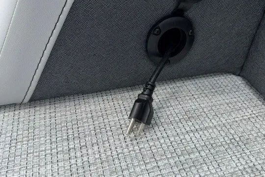 Slide: The Image of Power cord outlet in Alera M25Q, 2027 model, on gray fabric upholstery. - 24