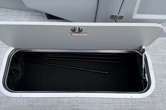 Slide: The Image of Open storage compartment in a 2027 Alera M25Q boat, showing interior space and rods. - 50