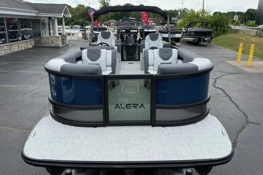 Slide: The Image of 2027 Alera M25Q pontoon boat with sleek seating, displayed in a dealership lot. - 5