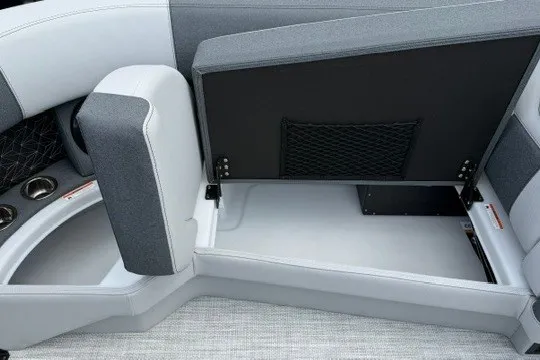 Slide: The Image of 2027 Alera M25Q boat interior with open storage compartment and cup holders. - 57