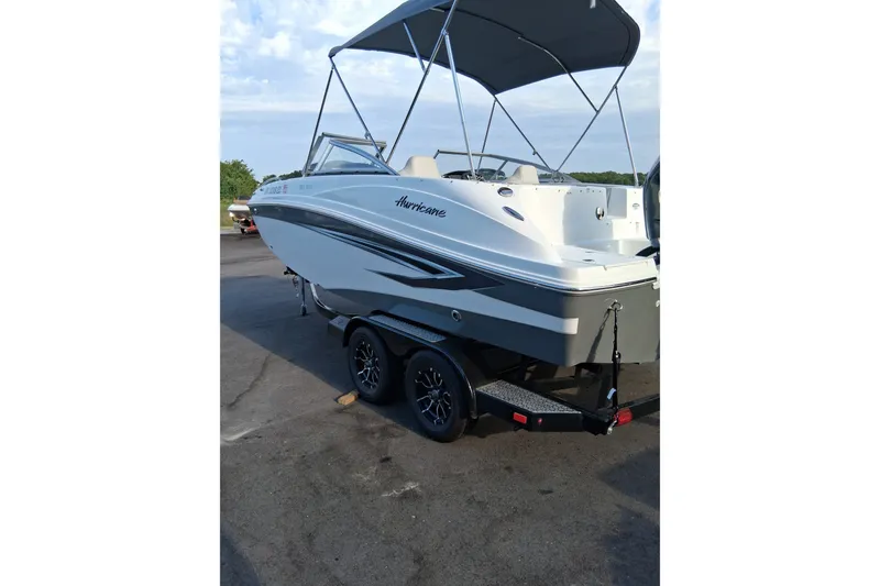 Slide: The Image of 2024 Hurricane SunDeck 191 OB boat on trailer, featuring sleek design and canopy. - 5