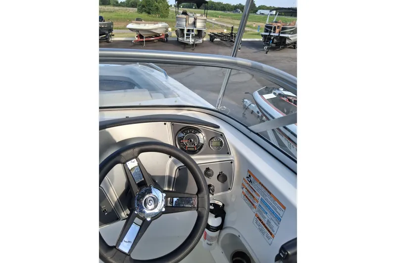 Slide: The Image of 2024 Hurricane SunDeck 191 OB boat dashboard with steering wheel and gauges. - 16