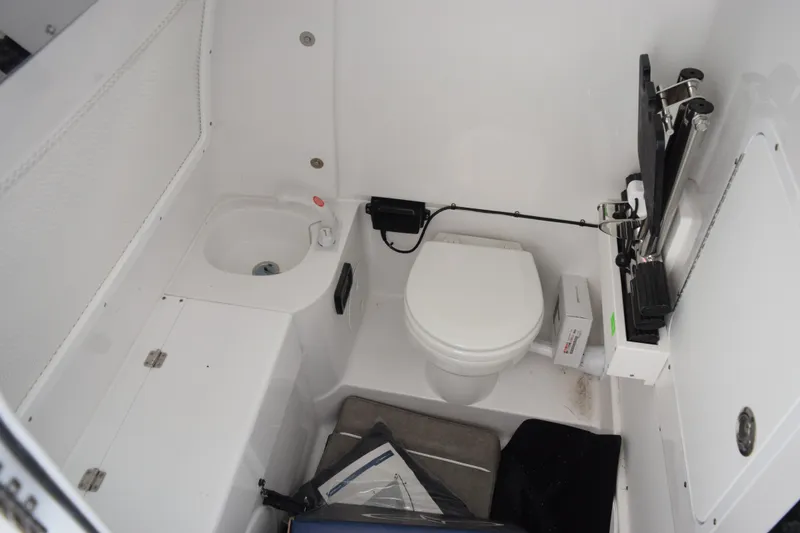 Slide: The Image of Interior of 2027 Sea Hunt Gamefish 28CB boat featuring compact bathroom amenities. - 19