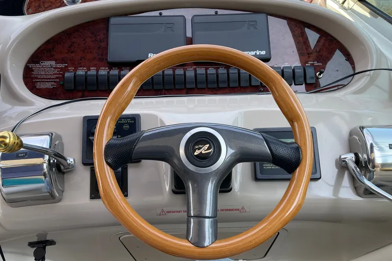 Slide: The Image of Steering wheel of a 2000 Sea Ray 380 Sundancer boat, featuring control panels. - 21