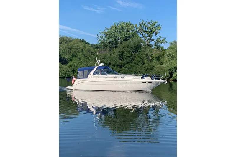 Slide: The Image of 2000 Sea Ray 380 Sundancer yacht cruising on a serene lake with lush greenery. - 30