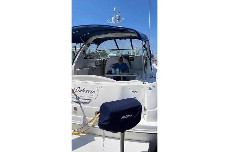 Slide: The Image of 2000 Sea Ray 380 Sundancer yacht docked, featuring a covered seating area and visible equipment. - 23