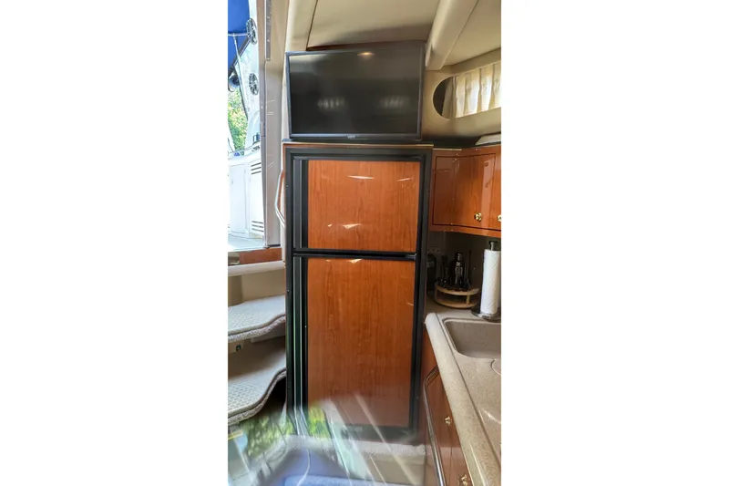 Slide: The Image of Interior of 2000 Sea Ray 380 Sundancer with wooden cabinetry and compact kitchen area. - 29
