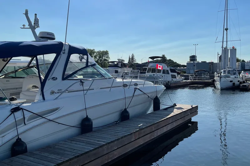 Slide: The Image of 2000 Sea Ray 380 Sundancer docked at a marina with Canadian flags visible. - 24