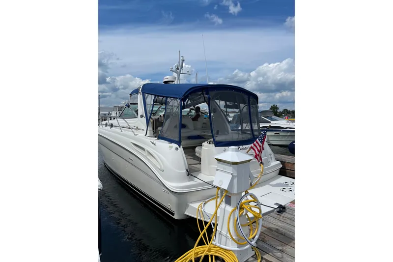Slide: The Image of 2000 Sea Ray 380 Sundancer yacht docked with blue canopy and American flag. - 4