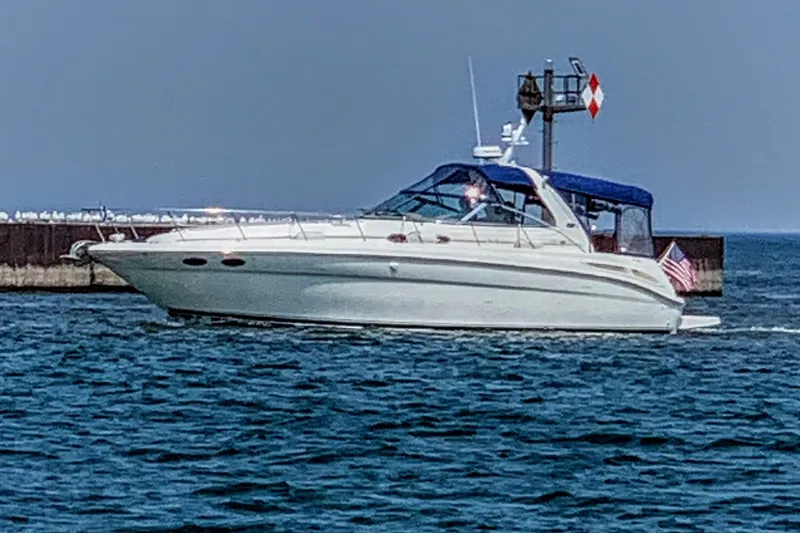 Slide: The Image of 2000 Sea Ray 380 Sundancer yacht cruising near a pier on a sunny day. - 31