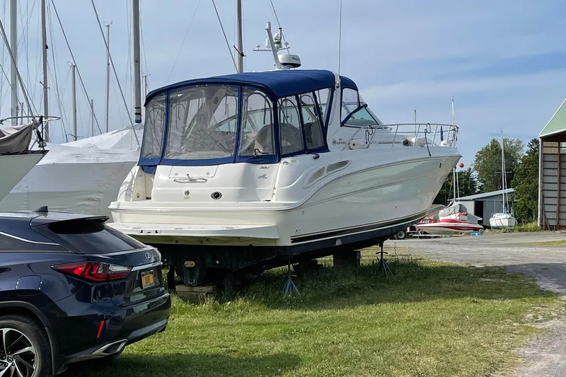 Slide: The Image of 2000 Sea Ray 380 Sundancer yacht on land, near parked car, marina background. - 5