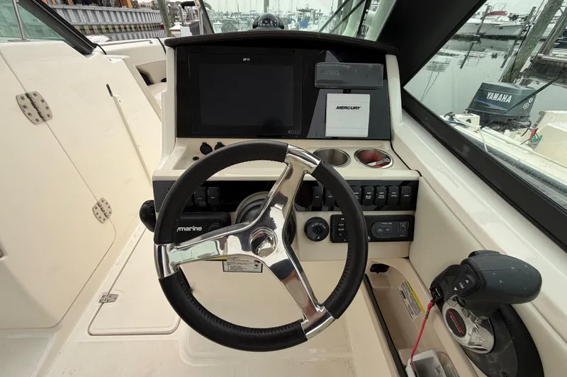 Slide: The Image of 2022 Boston Whaler 240 Vantage boat dashboard with steering wheel and control panel. - 25