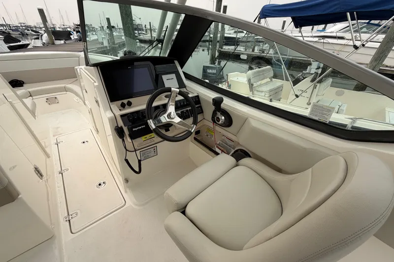 Slide: The Image of 2022 Boston Whaler 240 Vantage boat cockpit with steering wheel and control panel. - 22