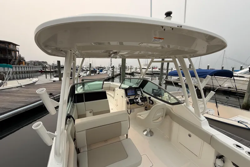 Slide: The Image of 2022 Boston Whaler 240 Vantage boat interior at marina, showcasing helm and seating area. - 47
