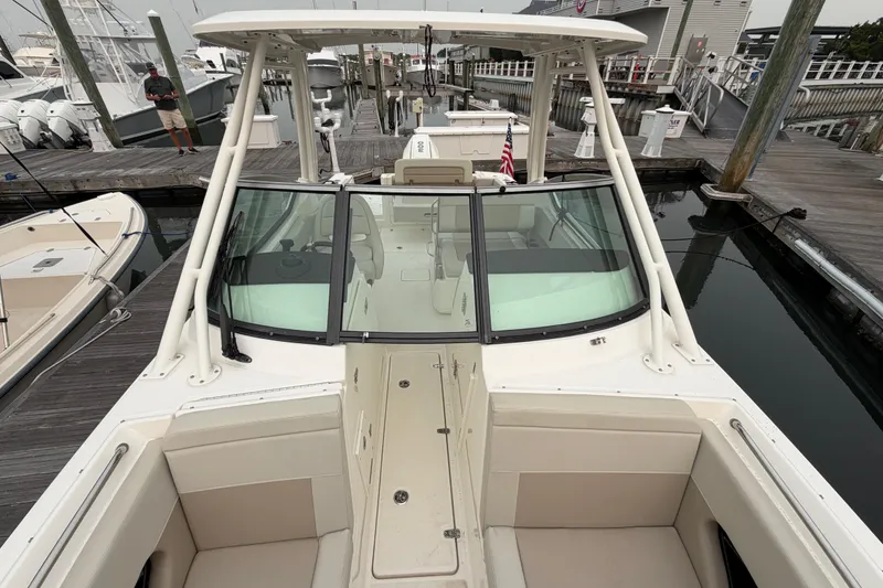 Slide: The Image of 2022 Boston Whaler 240 Vantage docked at a marina, showcasing spacious seating and sleek design. - 19