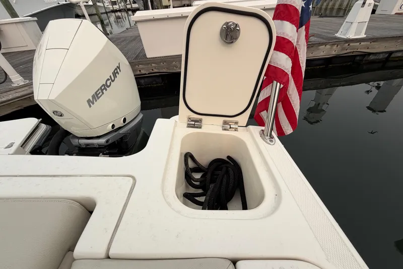 Slide: The Image of 2022 Boston Whaler 240 Vantage boat with Mercury engine and American flag at dock. - 49