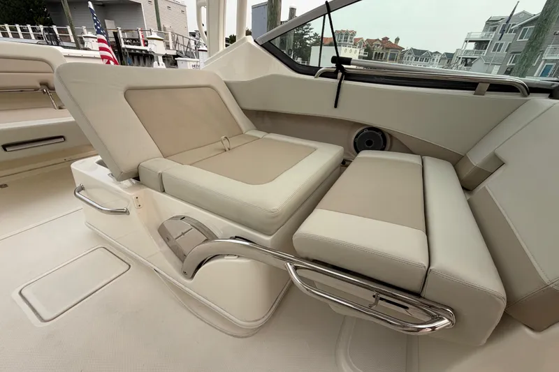 Slide: The Image of 2022 Boston Whaler 240 Vantage interior seating with beige upholstery and stainless steel accents. - 43