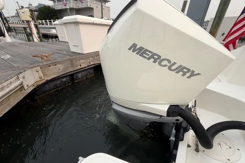 Slide: The Image of Outboard motor on a 2022 Boston Whaler 240 Vantage docked by a wooden pier. - 54