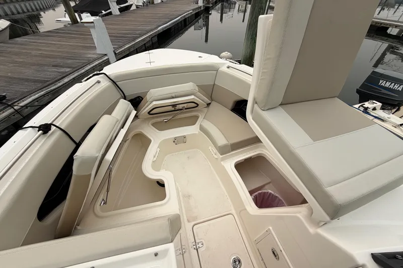 Slide: The Image of 2022 Boston Whaler 240 Vantage boat interior with spacious seating and storage at a marina. - 13