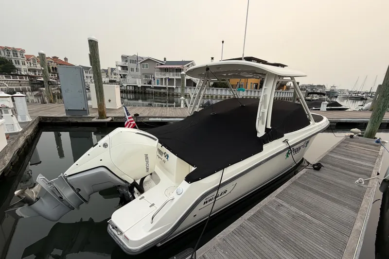 Slide: The Image of 2022 Boston Whaler 240 Vantage docked, covered, with Mercury outboard engine. - 64