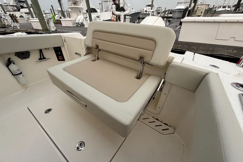 Slide: The Image of 2022 Boston Whaler 240 Vantage boat seat with beige upholstery at a marina. - 45
