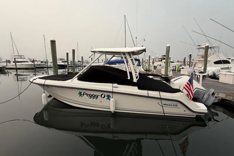 Slide: The Image of 2022 Boston Whaler 240 Vantage boat docked at marina with American flag. - 62