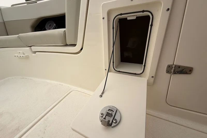 Slide: The Image of 2022 Boston Whaler 240 Vantage boat storage compartment with open hatch and latch. - 14