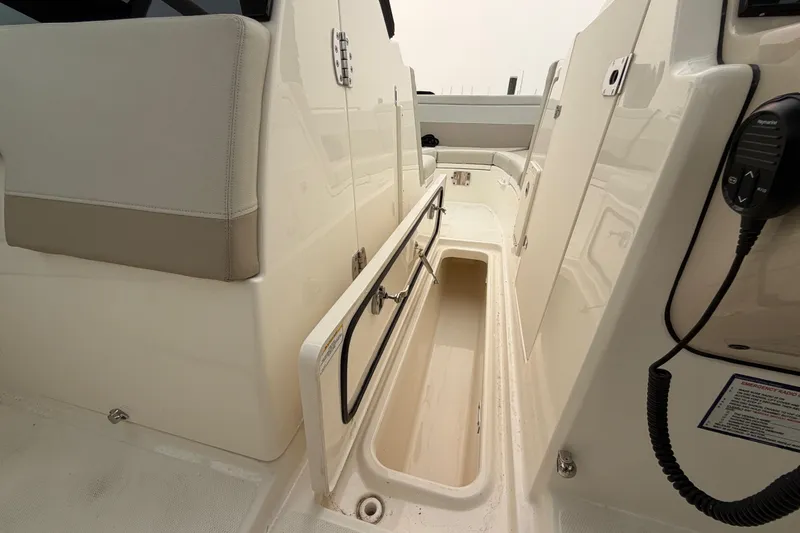 Slide: The Image of 2022 Boston Whaler 240 Vantage interior storage compartment with open hatch and seating. - 15