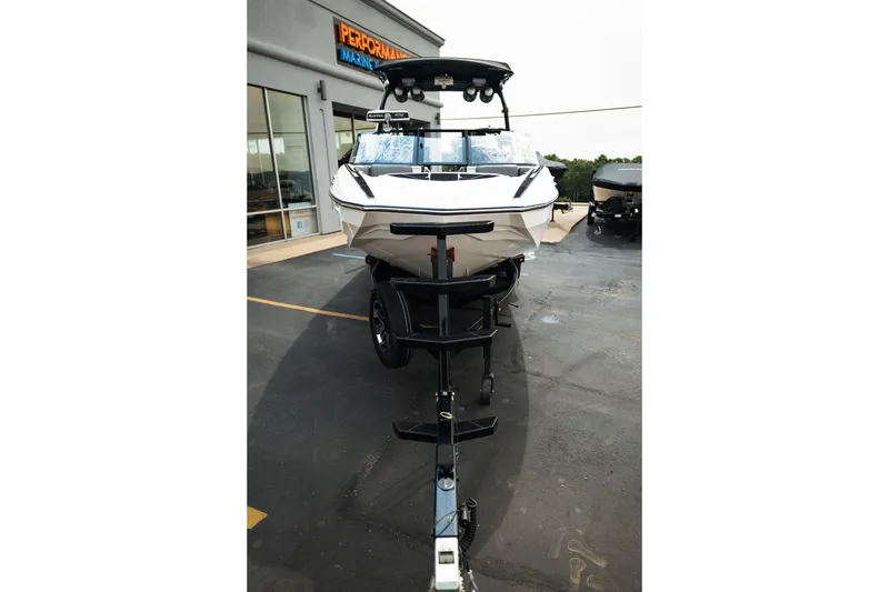 Slide: The Image of 2023 Supra SL 450 boat on trailer at dealership parking lot. - 14