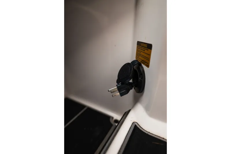Slide: The Image of 2023 Supra SL 450 power outlet with warning label in interior view. - 25