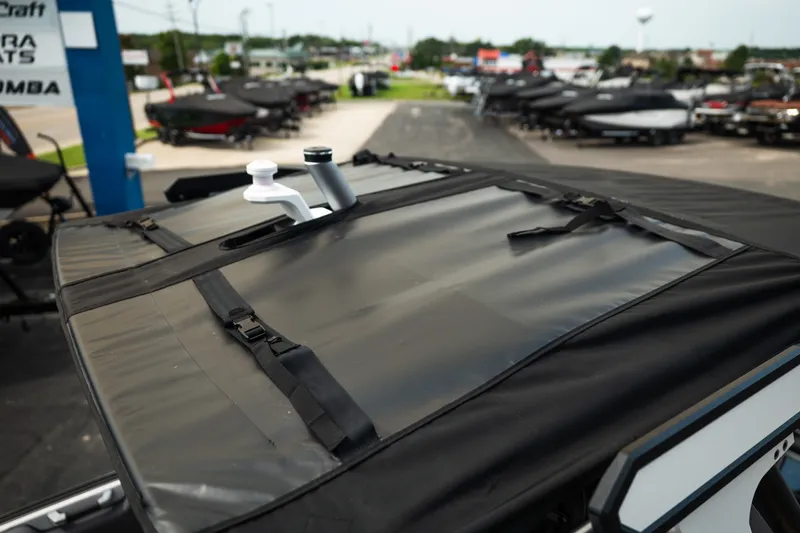 Slide: The Image of 2023 Supra SL 450 boat with protective cover in a dealership lot. - 35