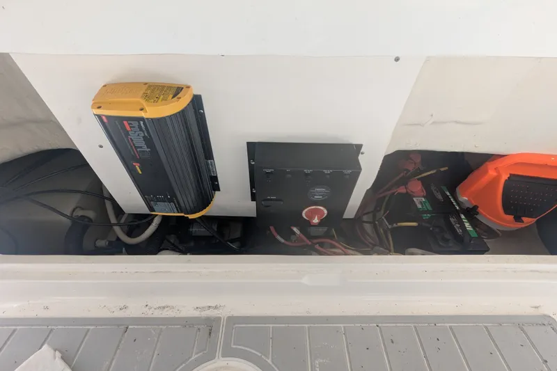 Slide: The Image of Electrical components in a 2018 Robalo R227 Dual Console boat, including battery and charger. - 16
