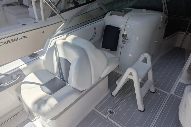 Slide: The Image of 2018 Robalo R227 Dual Console boat interior with white seating and step stool. - 14