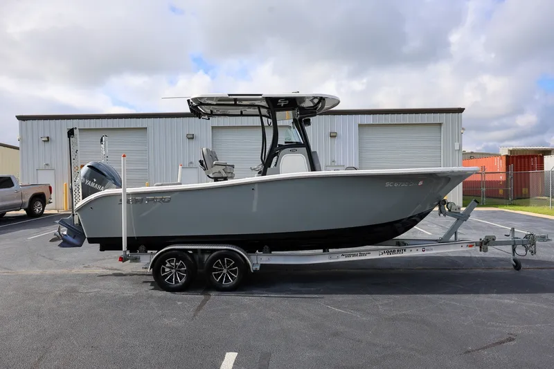 The Image of 2020 Sea Pro 239 Center Console boat on trailer, parked outside industrial building. - 1
