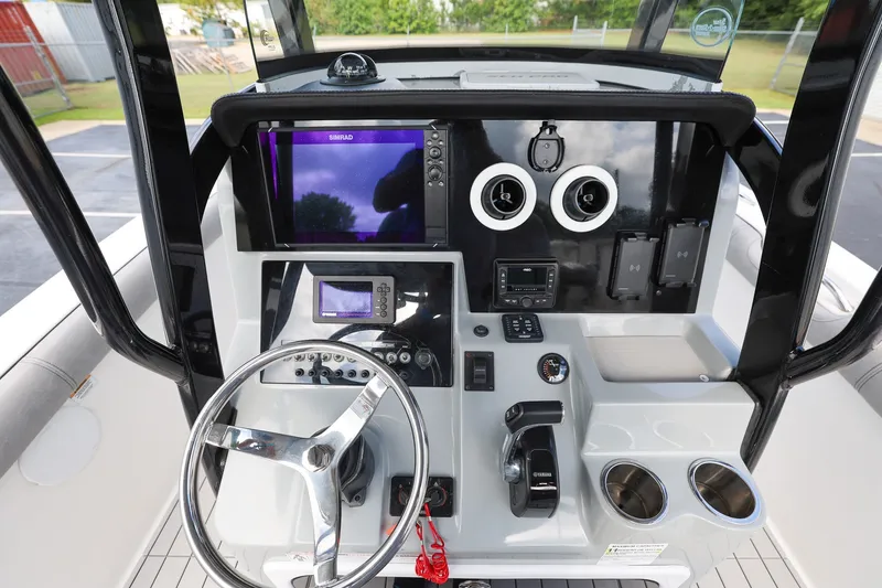 Slide: The Image of 2020 Sea Pro 239 Center Console boat dashboard with steering wheel and electronic controls. - 12