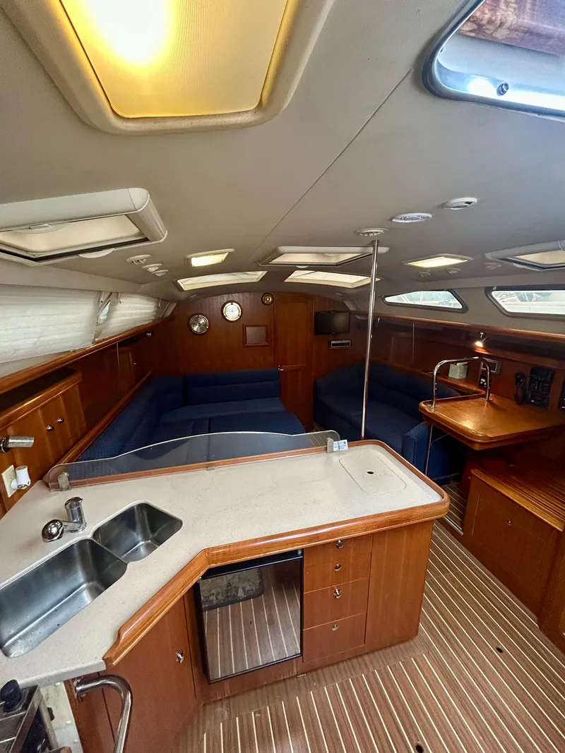 Slide: The Image of Interior of a 2005 Hunter 41 Aft Cockpit yacht with wood finish and blue upholstery. - 1