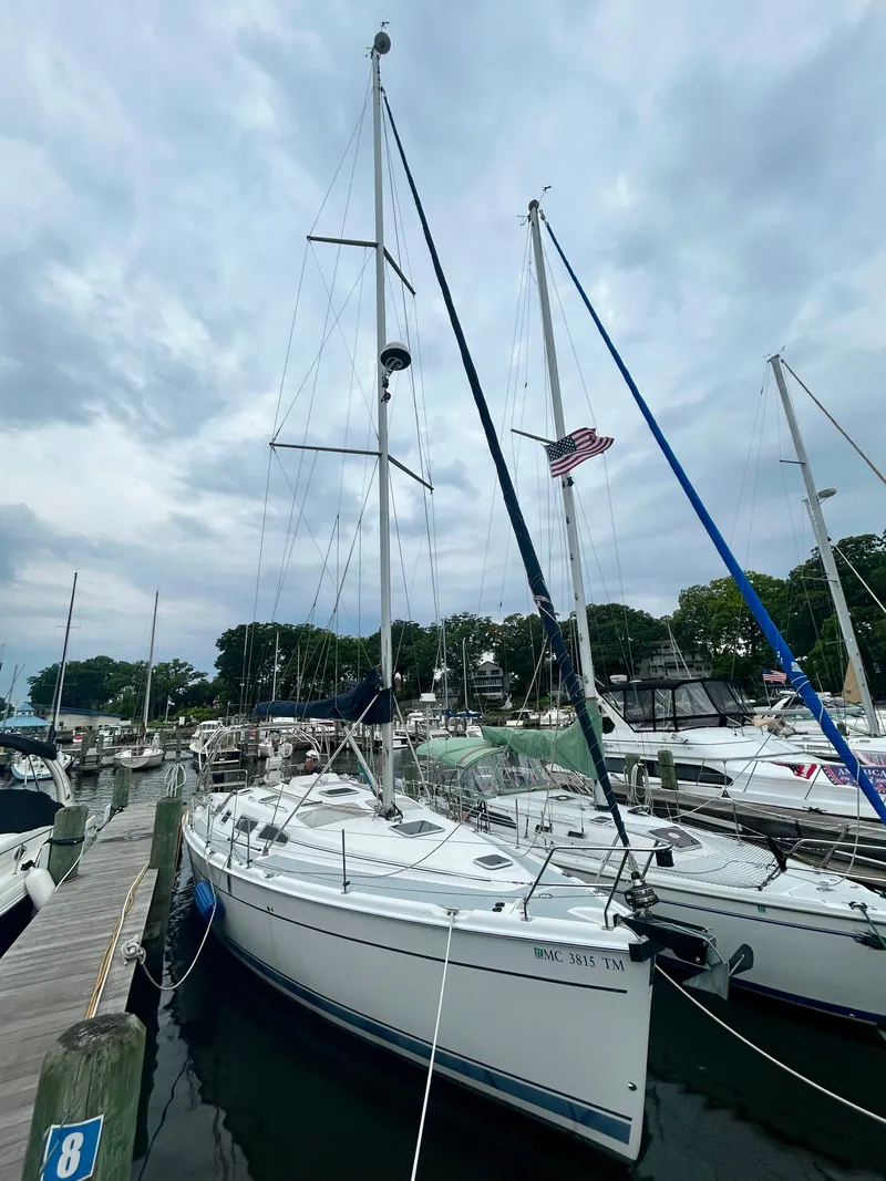 The Image of 2005 Hunter 41 Aft Cockpit sailboat docked, with masts and sails, surrounded by other boats. - 0