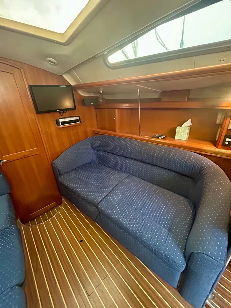 Slide: The Image of Interior of a 2005 Hunter 41 Aft Cockpit with blue upholstery and wood finish. - 6