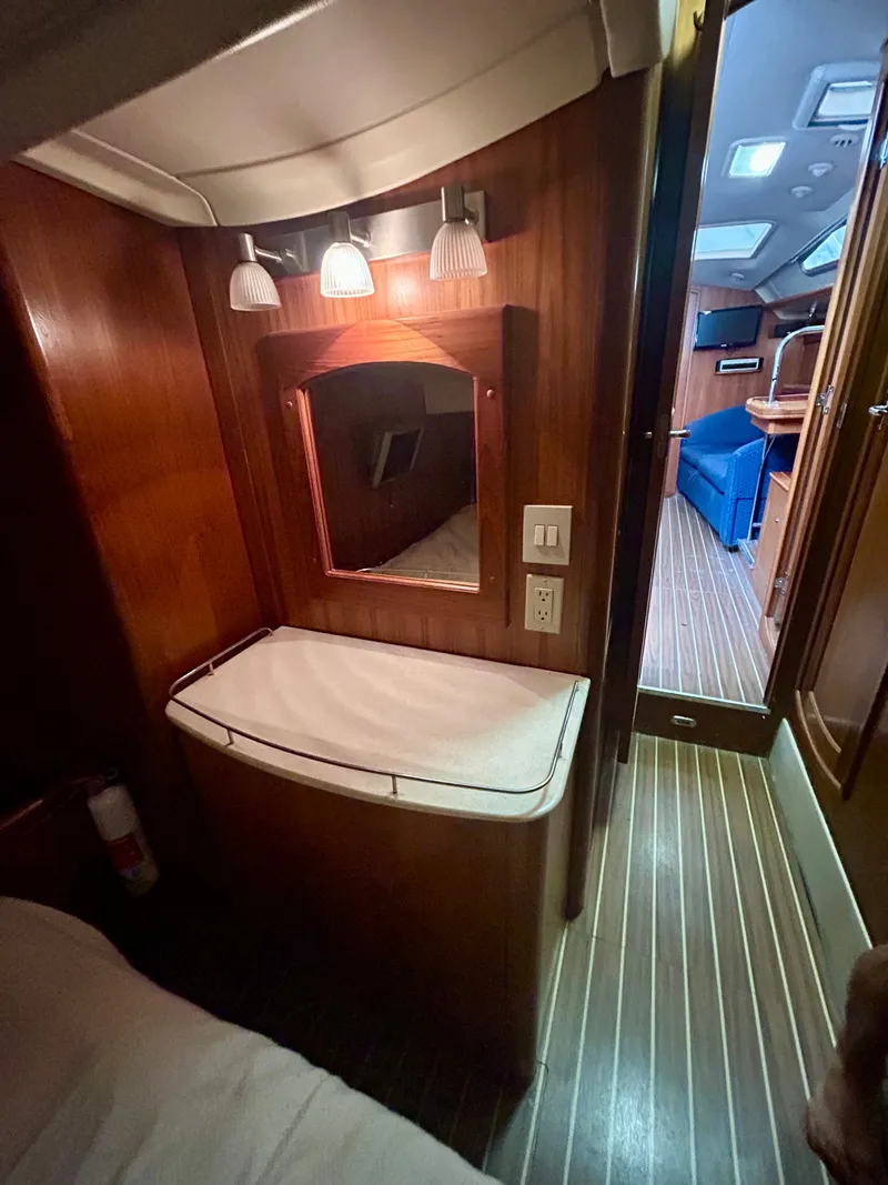 Slide: The Image of Interior of the 2005 Hunter 41 Aft Cockpit with wood paneling and a lit mirror. - 11