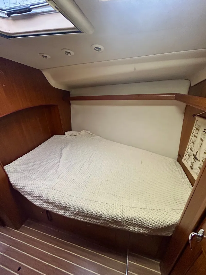 Slide: The Image of The cabin of a 2005 Hunter 41 Aft Cockpit with a cozy bed and wooden walls. - 25