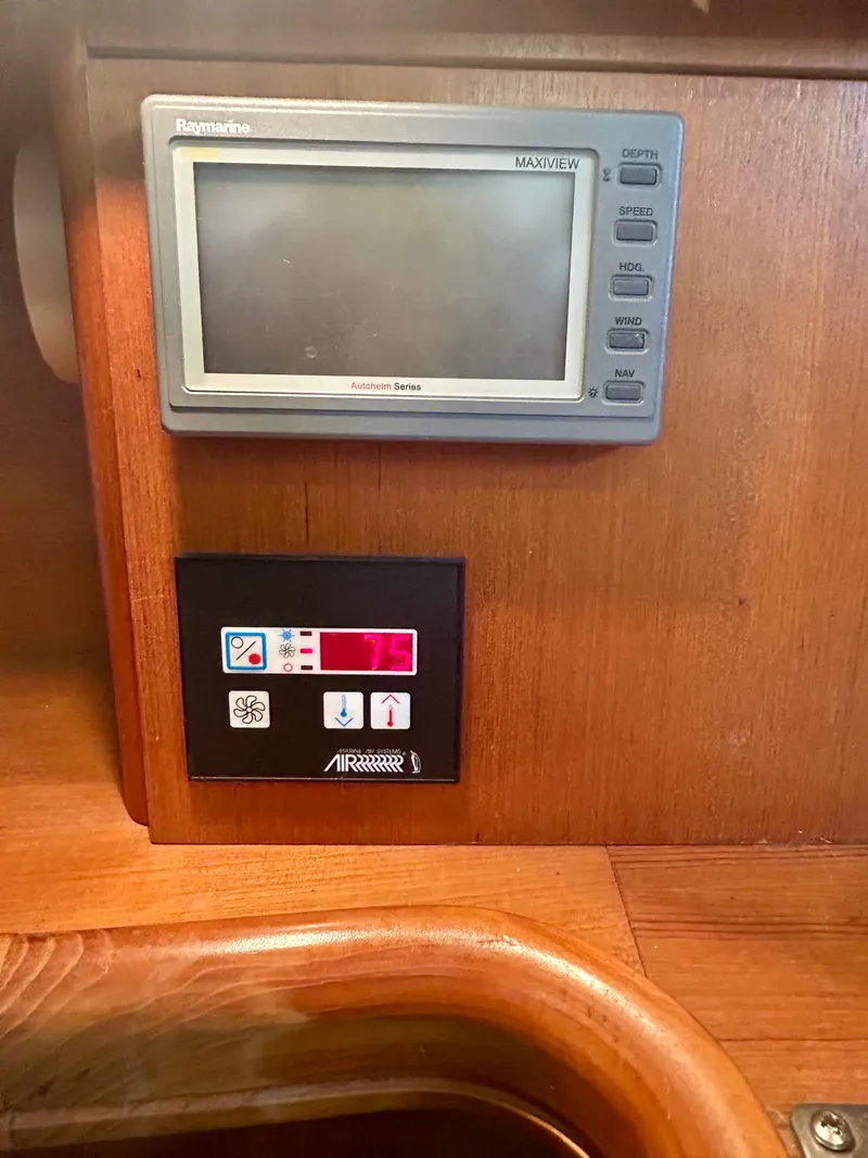 Slide: The Image of A Raymarine monitor and climate control panel are set into a wooden panel. - 7