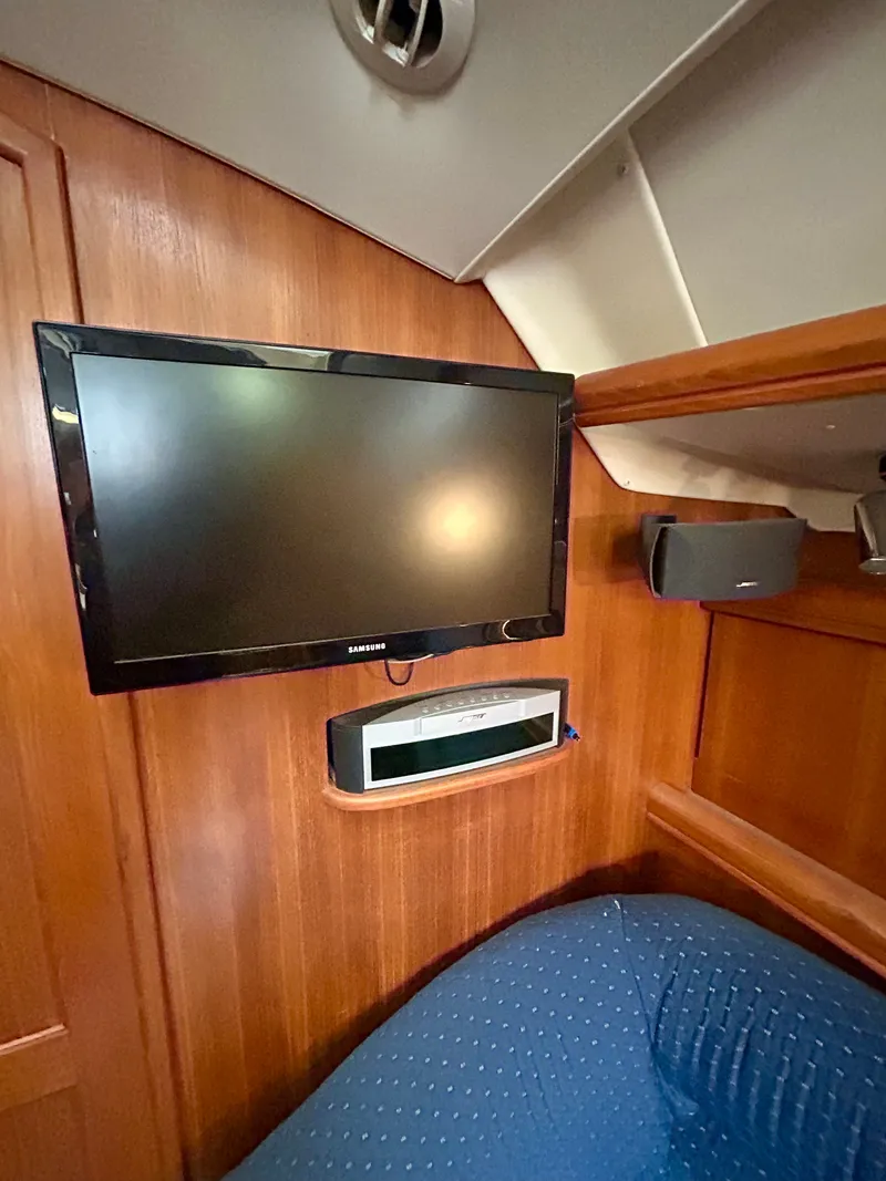 Slide: The Image of Interior of the 2005 Hunter 41 Aft Cockpit featuring a TV mounted on a wooden wall. - 15