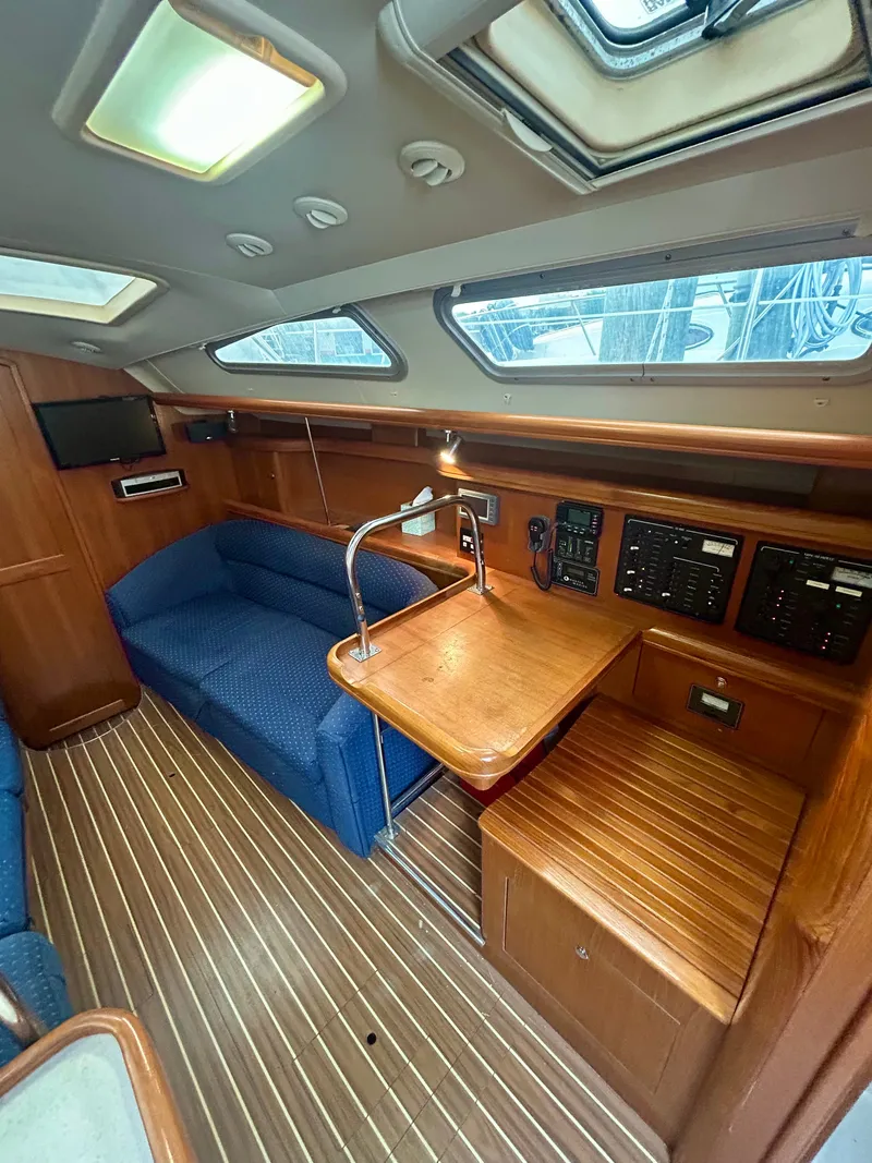 Slide: The Image of Interior of a 2005 Hunter 41 Aft Cockpit yacht with wood flooring and blue upholstery. - 2
