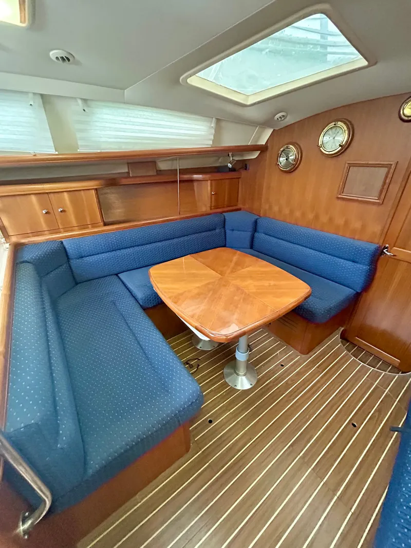 Slide: The Image of Interior of the 2005 Hunter 41 Aft Cockpit with blue upholstery and wooden table. - 17