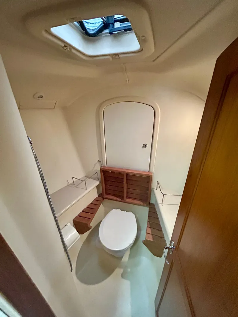 Slide: The Image of Interior view of a boat cabin with a toilet and wooden benches. - 24