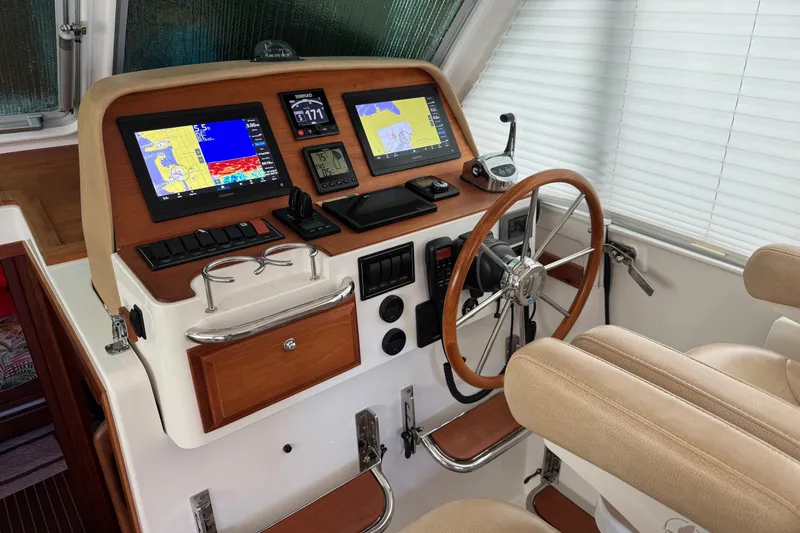 Slide: The Image of Helm of 2021 Back Cove 41 boat with navigation screens and wooden steering wheel. - 30