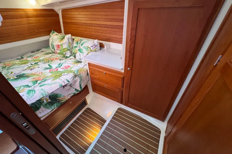 Slide: The Image of 2021 Back Cove 41 cabin interior with wood paneling and floral bedding. - 40