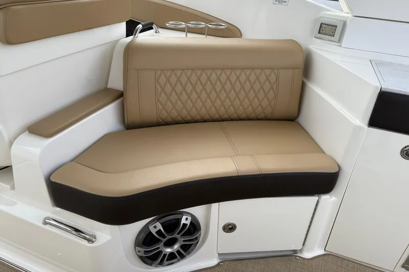 Slide: The Image of Luxurious seating on 2023 Sea Ray SLX 350 boat, featuring tan upholstery and integrated speaker. - 23