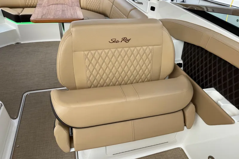 Slide: The Image of 2023 Sea Ray SLX 350 interior with tan leather seating and wooden table. - 25